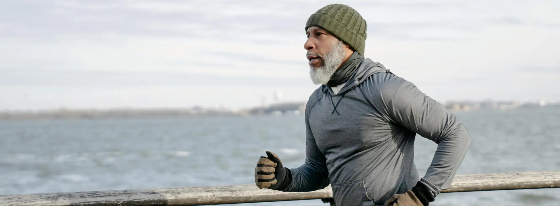 A man with long white beard and wearing gloves.